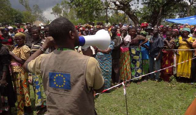 A man with a megaphone addresses a group of people