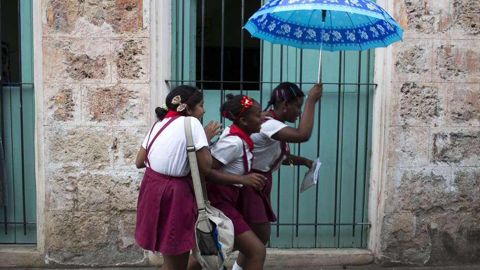 Girls in Cuba on their way to school in the rain.