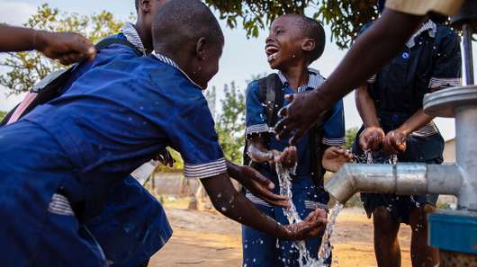 Children enjoy clean water at a well installed by Welthungerhilfe in Chitungwiza, Zimbabwe.