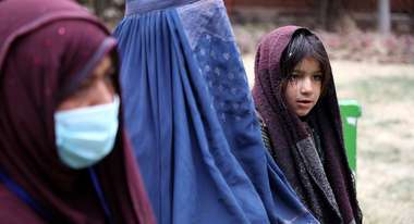 Zwei Frauen und ein junges Mädchen in Afghanistan. Eine der Frauen ist verschleiert, die andere trägt ein Kopftuch und einen Mund-Nase-Schutz. Das Mädchen trägt ein Kopftuch. 