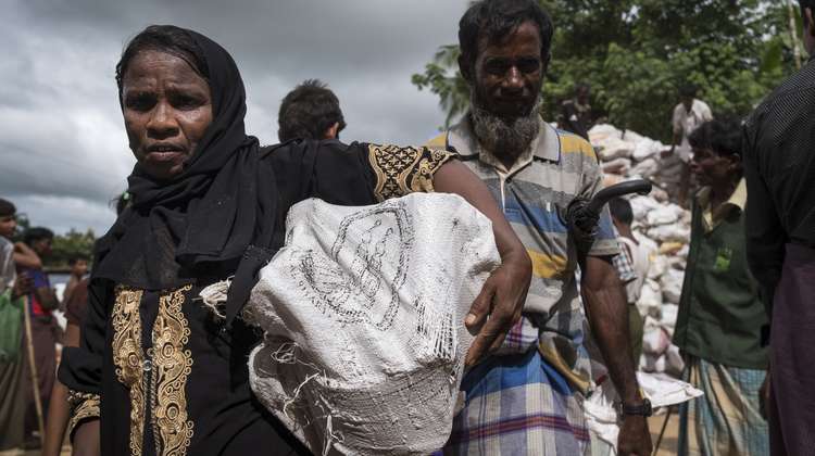 A woman in Hakimpara refugee camp in Bangladesh with a sack full of fuel. 