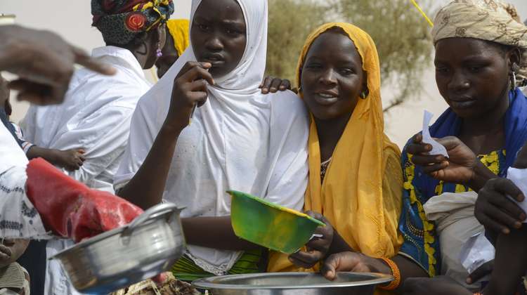 Young women in Niger holding bowls and pots