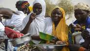 Young women in Niger holding bowls and pots