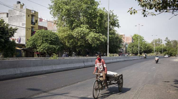 A rickshaw driver on an almost empty street.