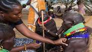 Dürre in Kenia: Eine Frau hält etwas Watte auf den Impfstich eines Mannes.