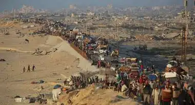 Aerial view of crowds of people and cars in the Gaza Strip fleeing along a road with their belongings.