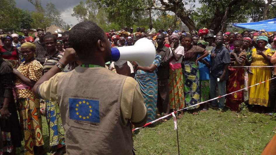 A man with a megaphone addresses a group of people