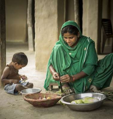 Eine Mutter bereitet mit ihrem Kind Gemüse zu. Nepal 2022.