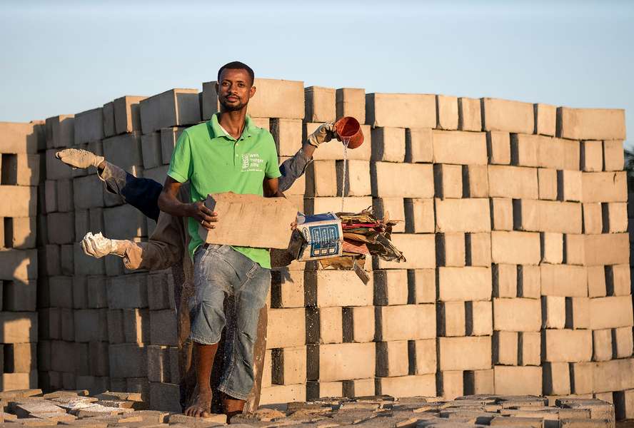 tand one behind the other and stretch out their arms, in each hand they hold a raw material for the production of bricks from waste materials.