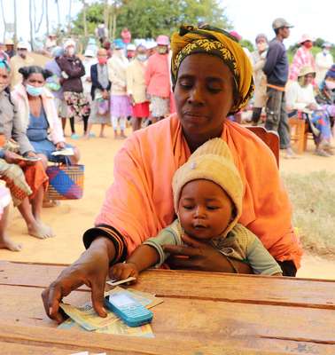 Eine Frau und ihr Baby beim Cash Transfer in Madagaskar.