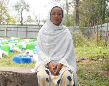 Eine junge Frau sitzt auf einer kleinen Mauer, Äthiopien 2022. 