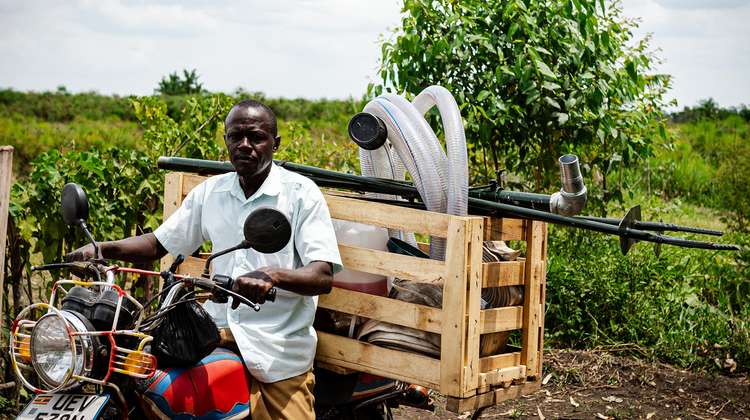 Ein Bauer in Uganda auf einem Moped, 2021.