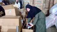 A woman unpacks boxes of relief goods.