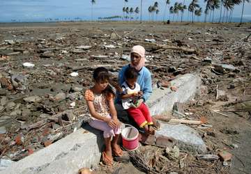 A mother with her children by the destroyed Aceh plains.