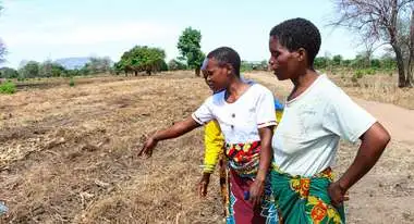 Nutrition Smart Community in Malawi: Drei Frauen beraten sich auf einem Feld