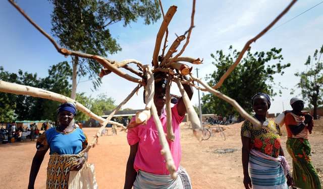 Frauen und Männer transportieren Holz in Dissin, Burkina Faso