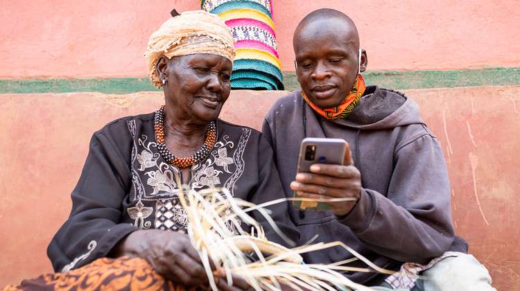 Zwei Landwirte in Uganda verwendet das Smartphone um Landarbeiter zu finden, 2021.