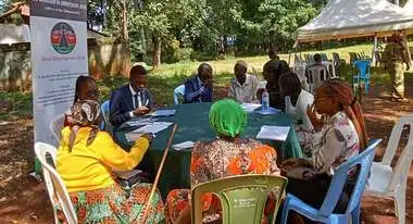 Legal counsel Vihiga County, Kenya. A group of men and women in conversation around a table.