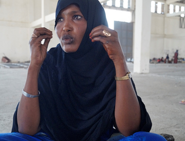 Eine Frau sitzt im auf dem Boden einer großen Halle, Äthiopien 2022.