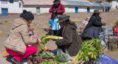 Indigene Menschen handeln mit Gemüse auf einem Markt im peruanischen Huaracco.