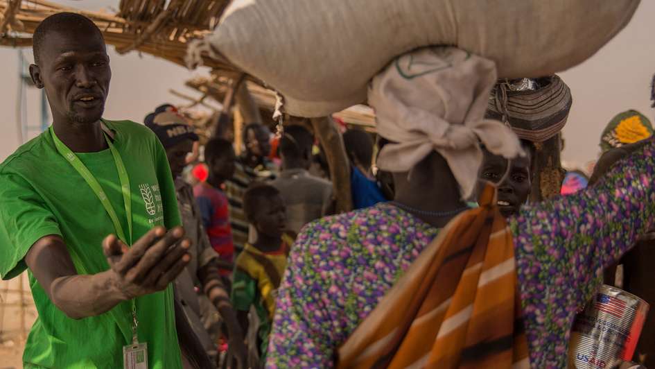 Refugees receive food items from Welthungerhilfe staff in a refugee camp in Bentiu, South Sudan.