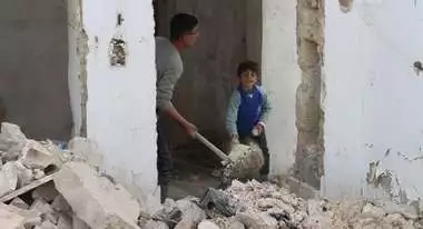 Two young boys in a destroyed house.