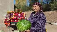 Eine Frau zeigt eine große Wassermelone, Tadschikistan 2021.