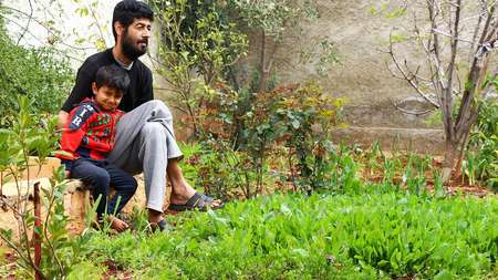 Obeida Yousef with his son in their vegetable garden