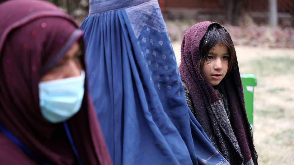 Zwei Frauen und ein junges Mädchen in Afghanistan. Eine der Frauen ist verschleiert, die andere trägt ein Kopftuch und einen Mund-Nase-Schutz. Das Mädchen trägt ein Kopftuch. 