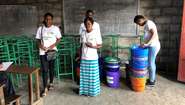 Welthungerhilfe staff with buckets and other handwashing equipment