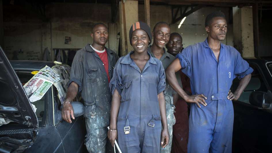 Uganda Skill Up Projekt Eine Gruppe Jugendlicher in einer Autowerkstatt