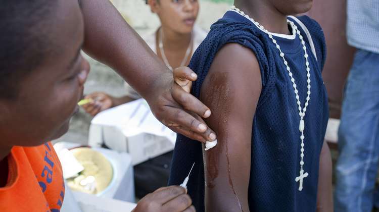 Eine Person impft eine andere Person in Haiti