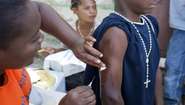 Eine Person impft eine andere Person in Haiti