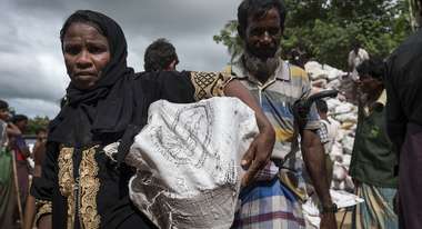A woman in Hakimpara refugee camp, Bangladesh, with a sack full of fuel.