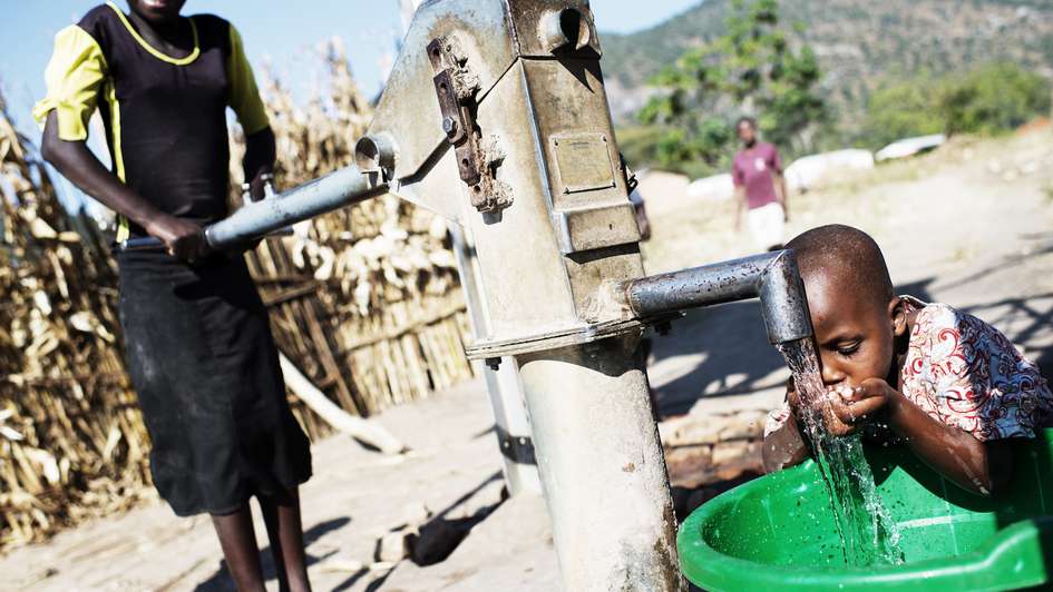 2014-wash-wasserpumpe-junge-trinkt-malawi-kai-loeffelbein-MLW2014LOEF007.jpg Junge trinkt Wasser an Brunnen.