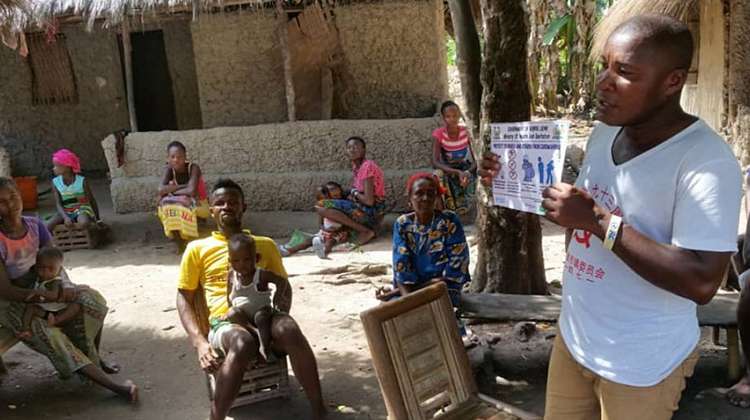 Community members in Bonthe District, Sierra Leone, receive information on behaviour that will help slow down transmission of the virus.
