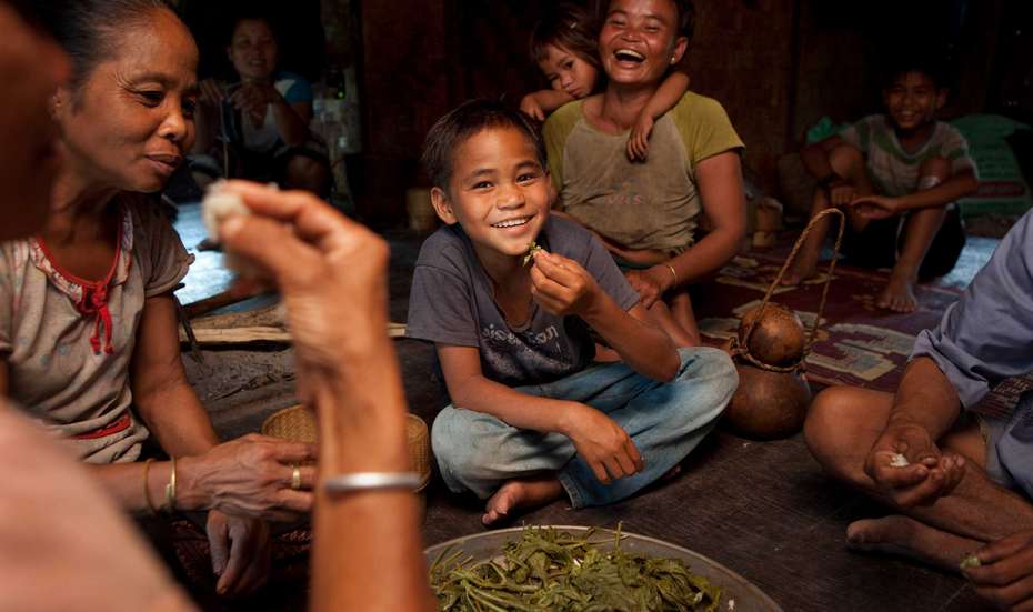 Adeu (2nd from left) sharing a meal with his family in the village of Khaysone, Laos.