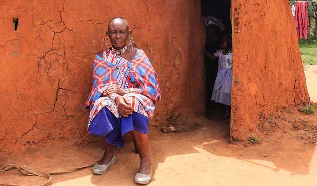 Massai Esther Sululi Makooi in front of cabin.