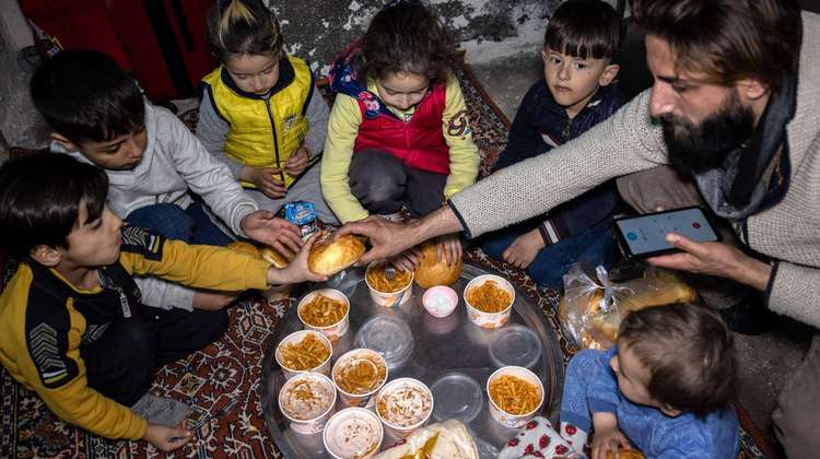 Eine Familie isst eine Mahlzeit der Suppenküche für Erdbebenopfer, Mardin/Türkei 2023.