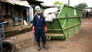 Waste management worker in work clothes and mouthguard.