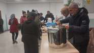 In a soup kitchen, food is served to people in need.