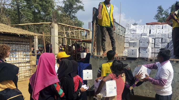 Rohingya refugees are handed packages from a lorry