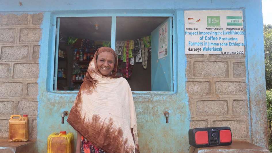 A woman in Ethiopia standing in front of a water kiosk where she can buy clean water