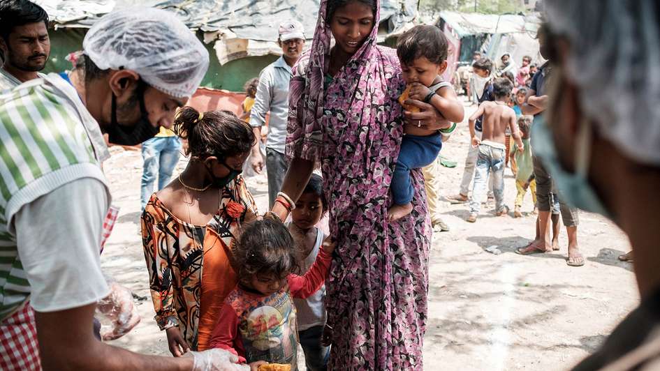 A woman with three children at a food distribution