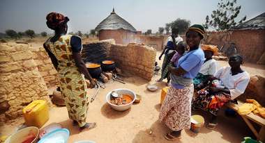 Women boil freshly harvested fruit and vegetables to create healthy food
